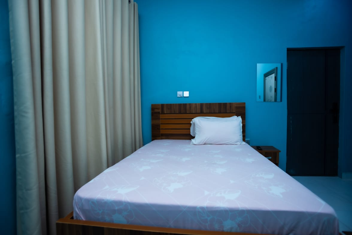 Block D Room with double bed, bedside table and wall TV