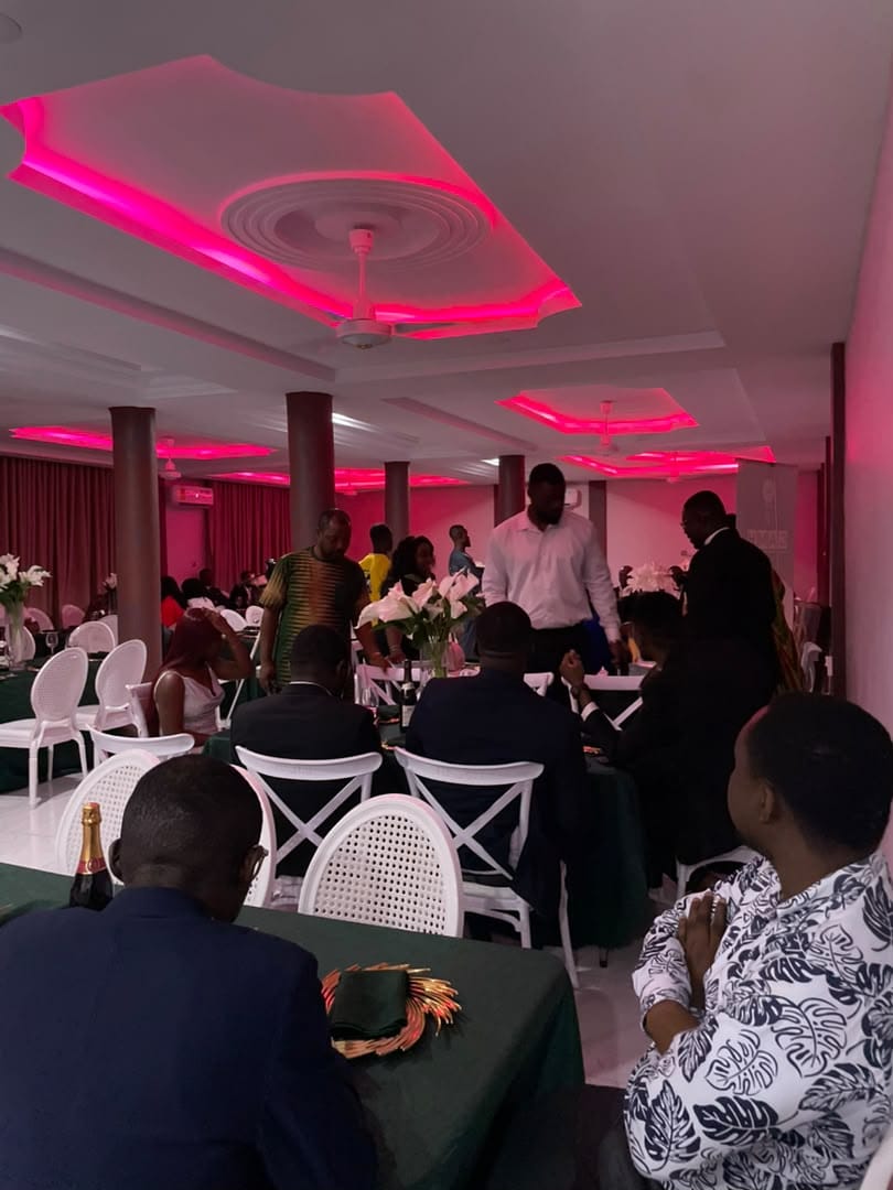 Guests dining at Abank Village restaurant under pink mood lighting
