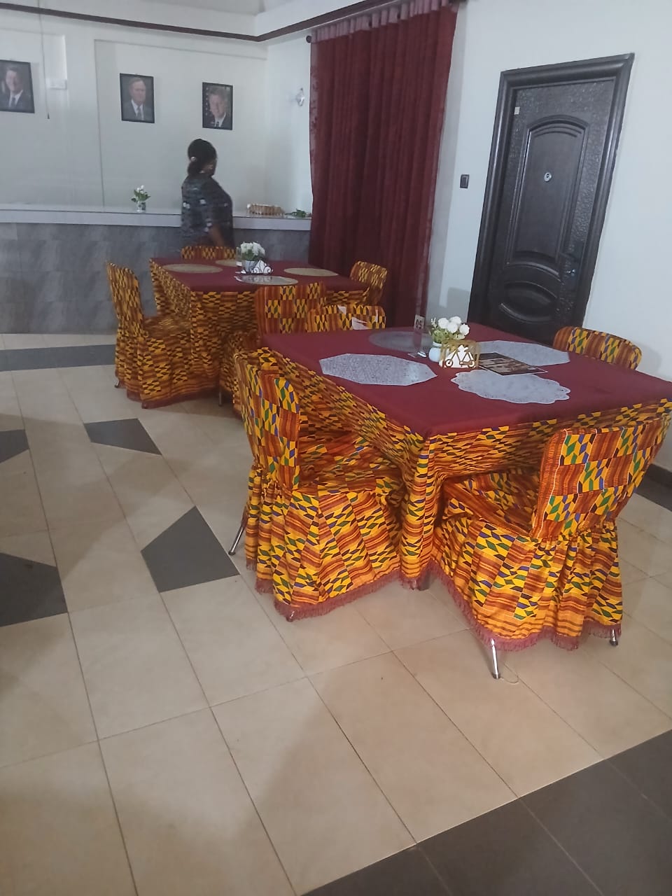 Kente-draped dining tables and service counter at Abank Village restaurant